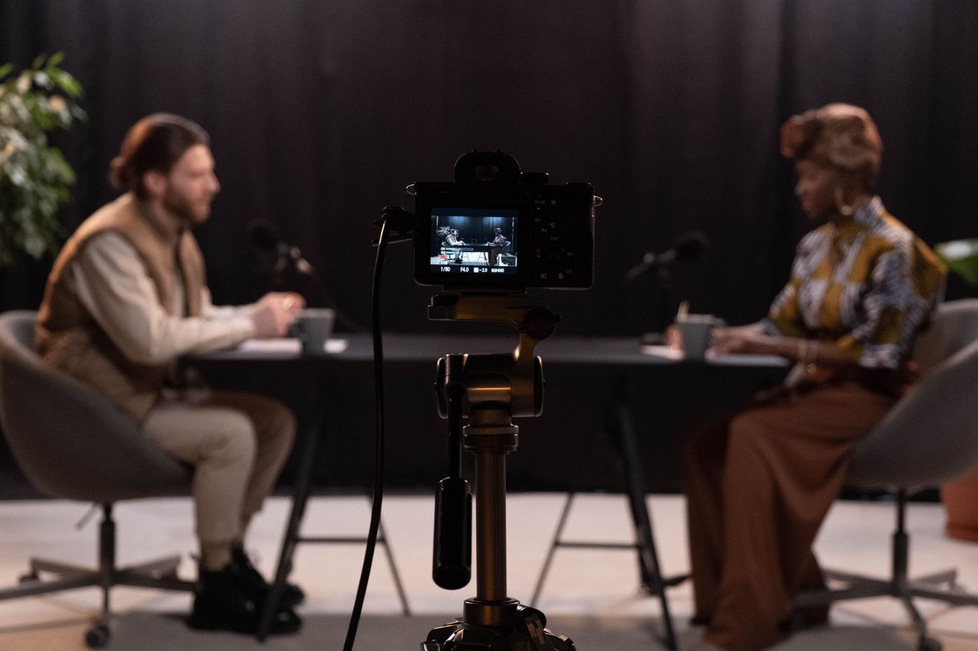 Two hosts recording in a studio