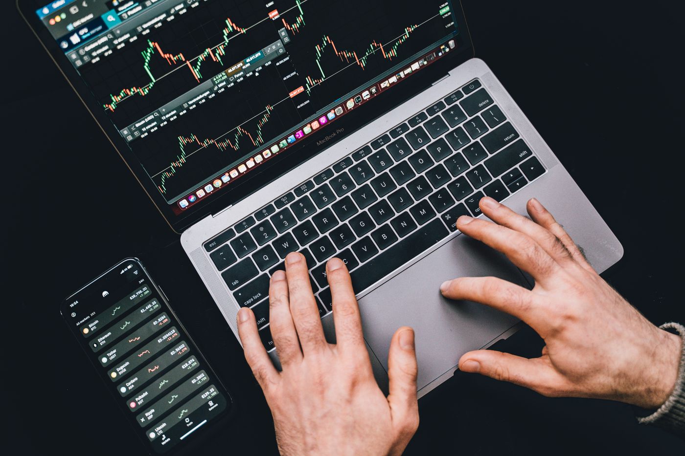 Trader working on a laptop with charts